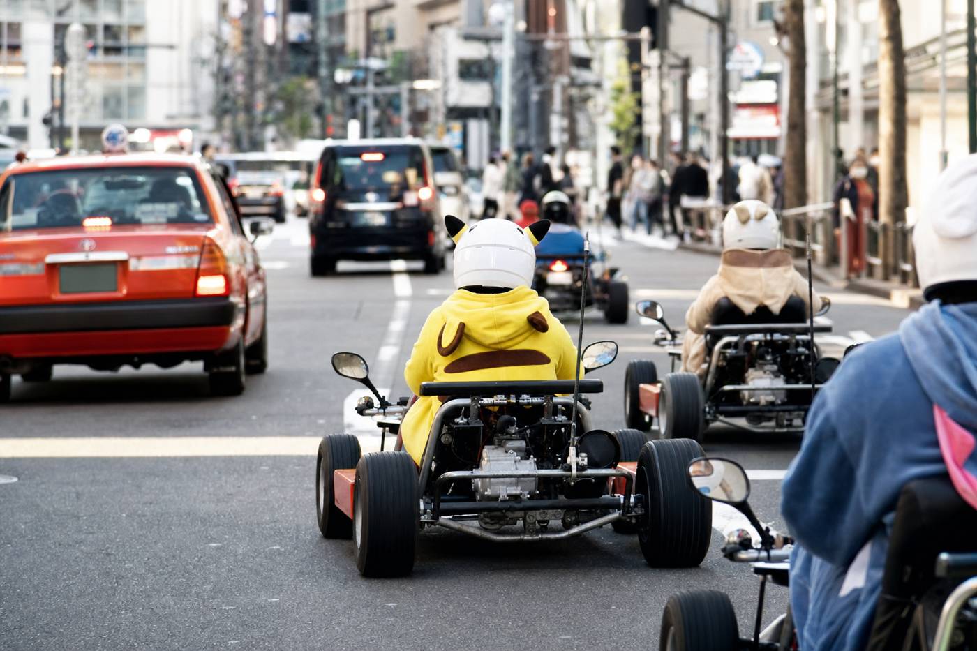 Ein Kart-Konvoi auf einer hellen Tokioter Allee in der Nachmittagssonne
