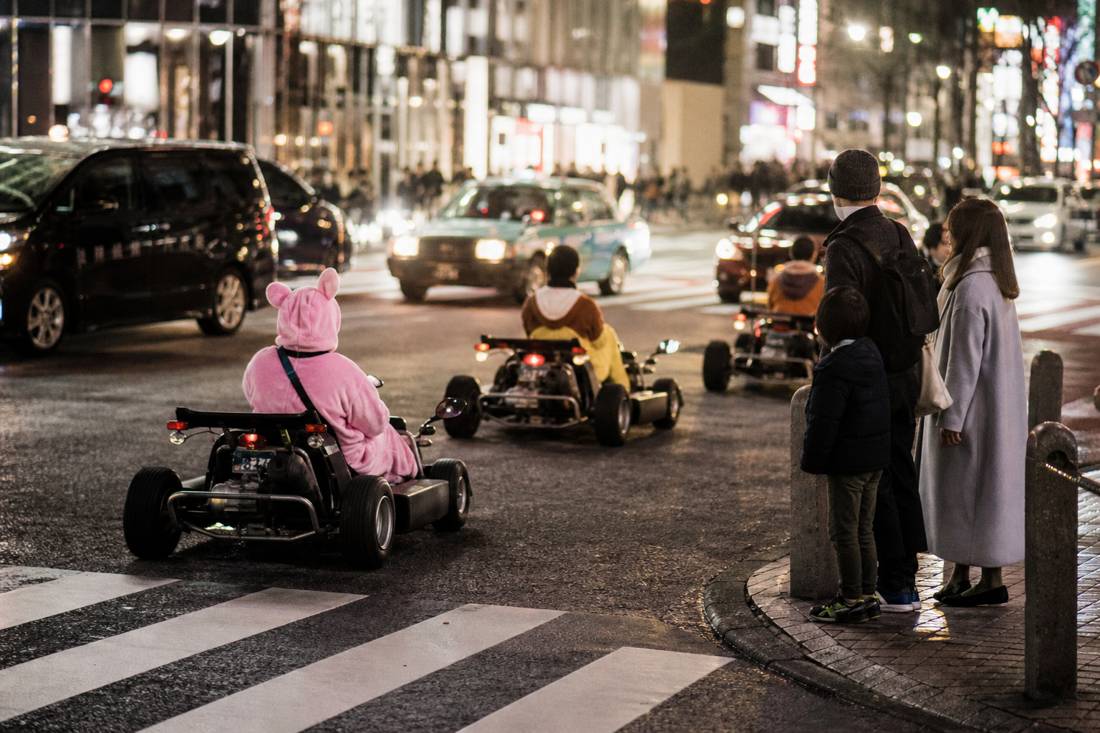Un groupe de karts passant devant une famille au carrefour de Shibuya