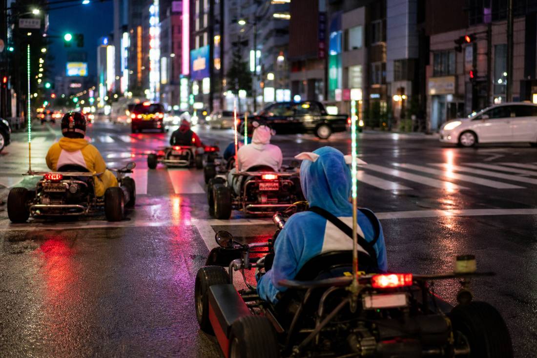 Eine Neonstraße in Tokio bei Nacht mit Karts