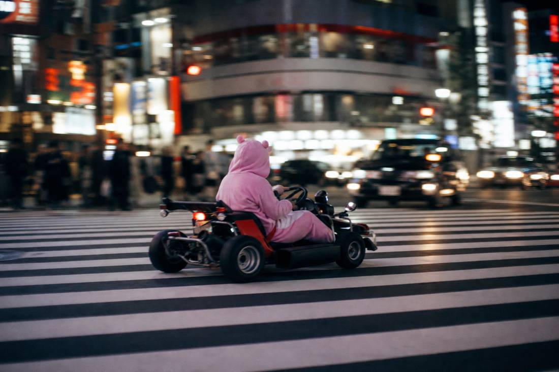 Un go-kart da strada che attraversa le ampie strisce dello Scramble di Shibuya