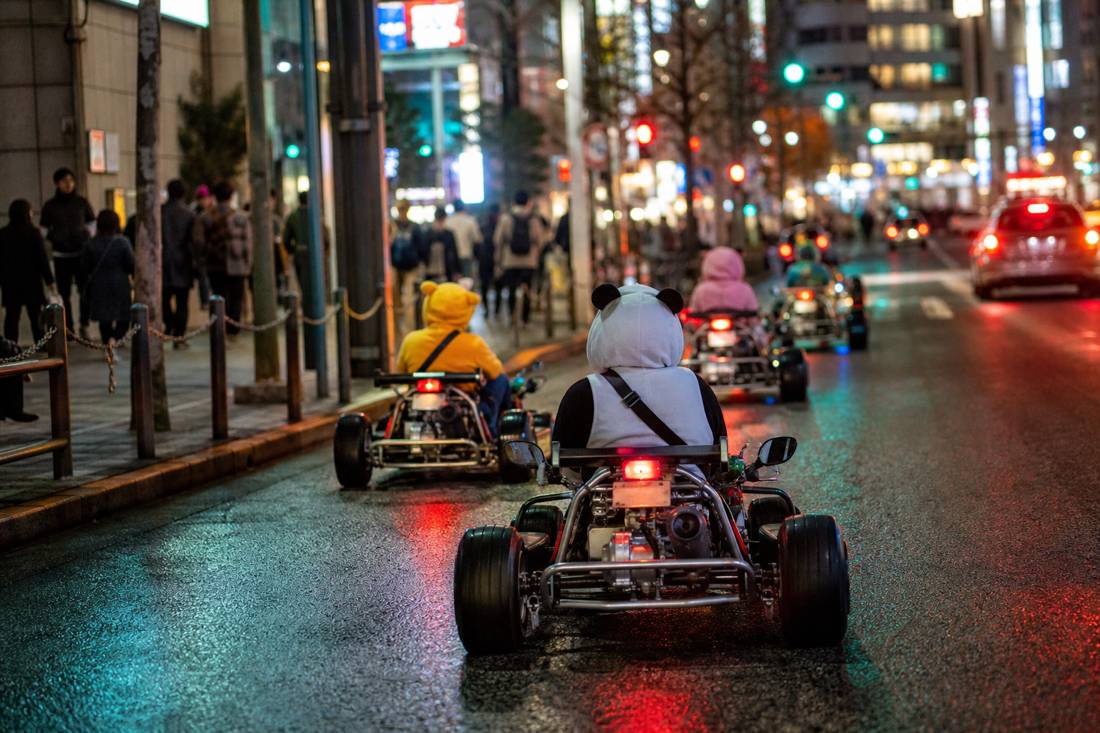 Go-kart da strada sullo Scramble di Shibuya di notte con i riflessi dei neon