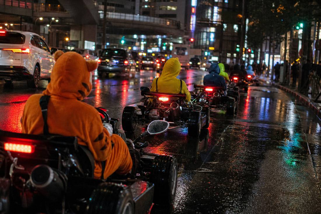 Un convoglio notturno di go-kart tra i neon di Tokyo