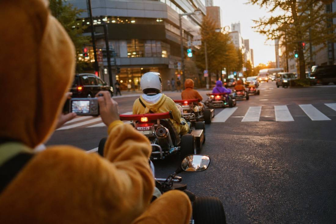 Un guide photographiant les conducteurs de karts pendant le tour à Tokyo