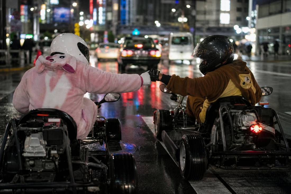 Deux karts côte à côte à un feu rouge de Tokyo