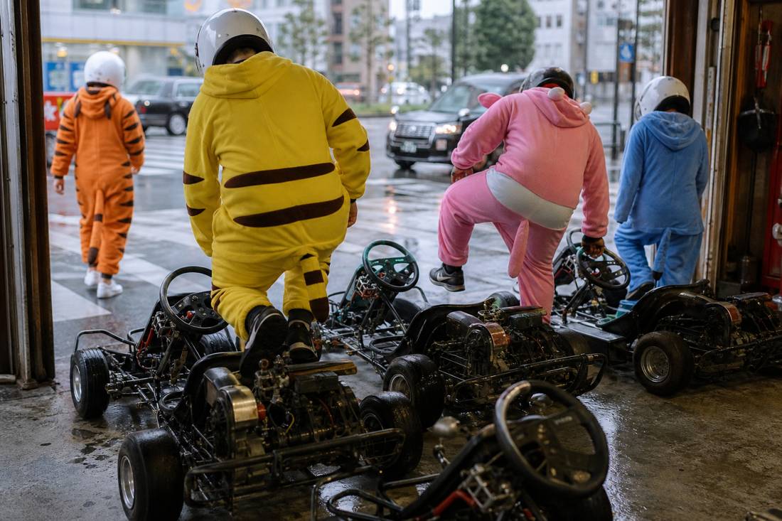 Un gruppo in costume che sale sui go-kart in un garage di Tokyo