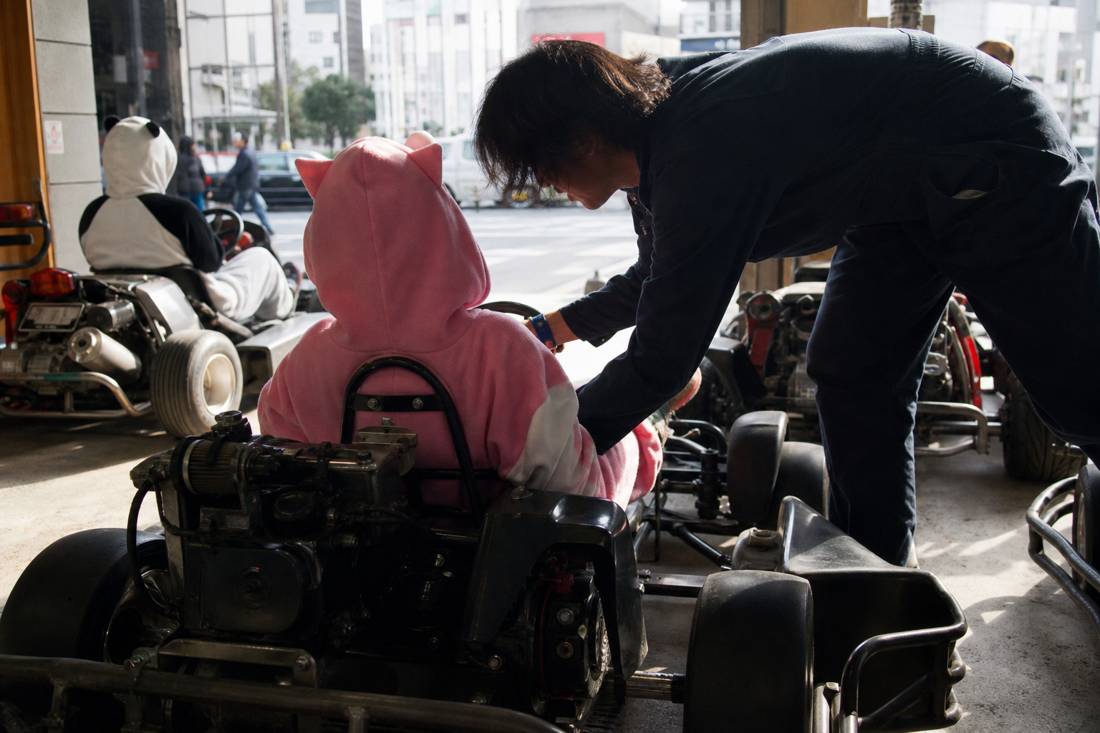Il personale che aiuta un guidatore anziano a sedersi nel go-kart