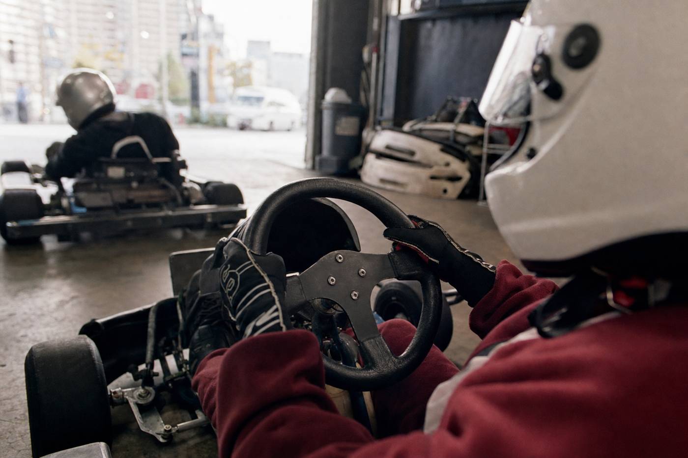 Behandschuhte Hände am Lenkrad eines Street-Karts in Tokio