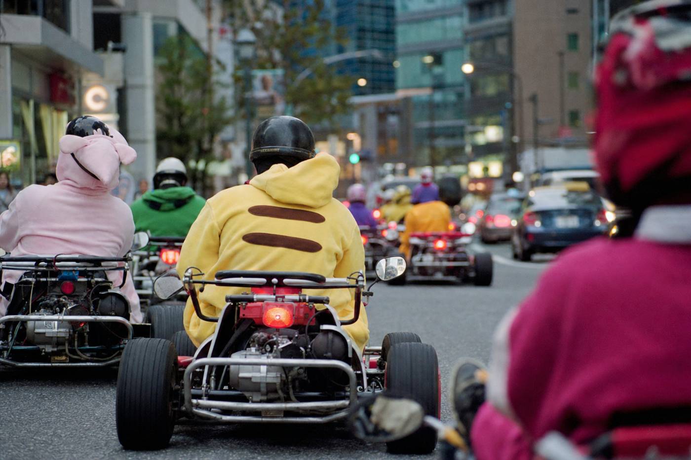 Un convoglio di kart che oggi percorre una luminosa strada di Tokyo