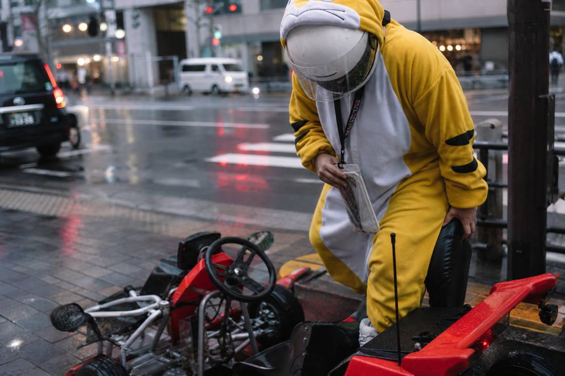 Ein Fahrer mit Helm steigt in ein Street-Kart