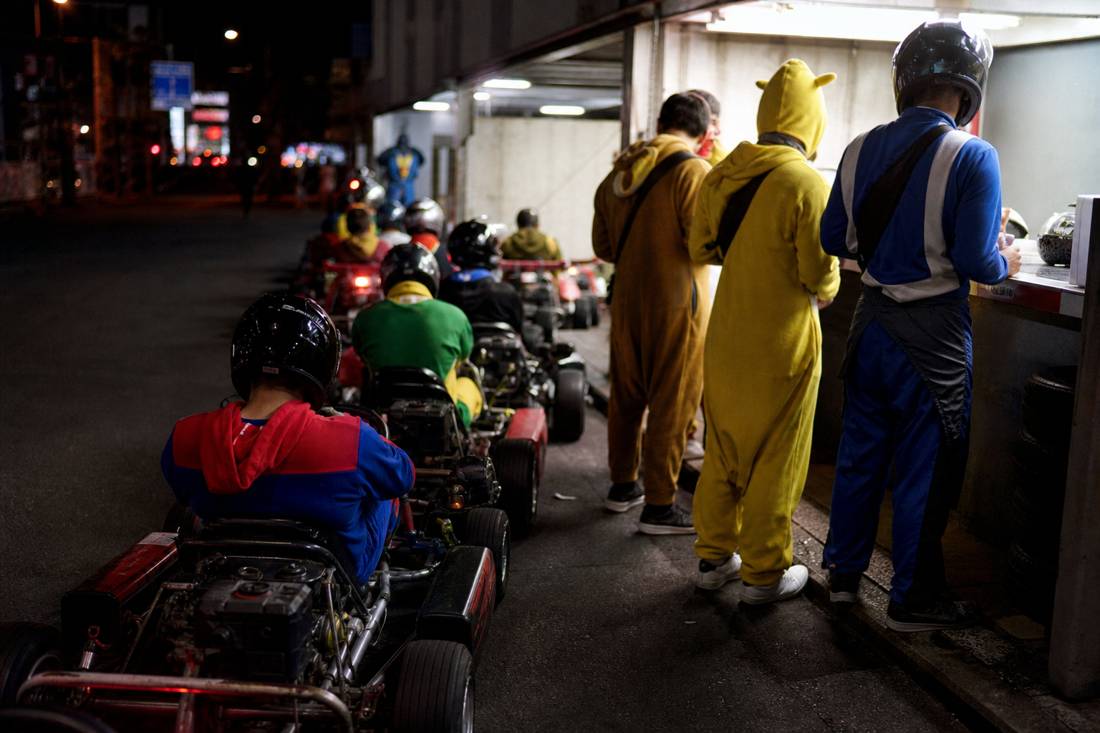 Guidatori al banco d'ingresso di un garage di go-kart a Tokyo